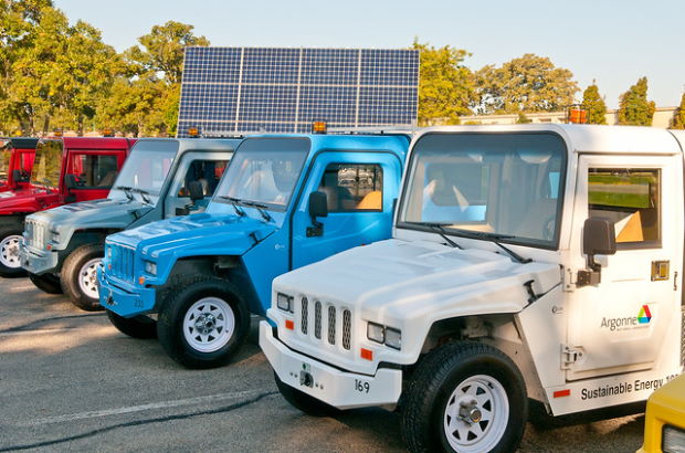 four electric vehicles sit parked on a sunny day