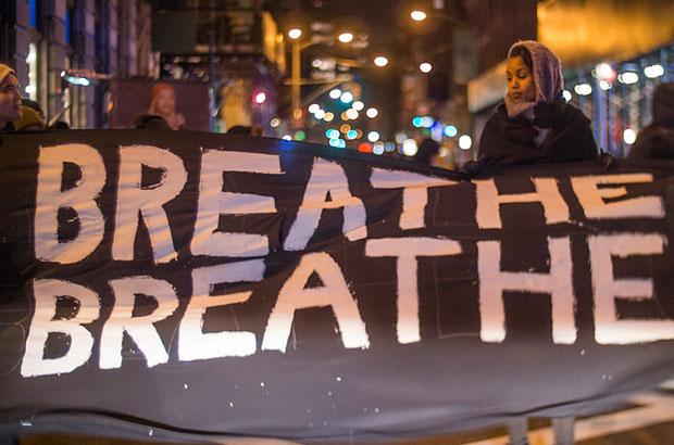 woman holding protest sign saying "breathe breathe" 