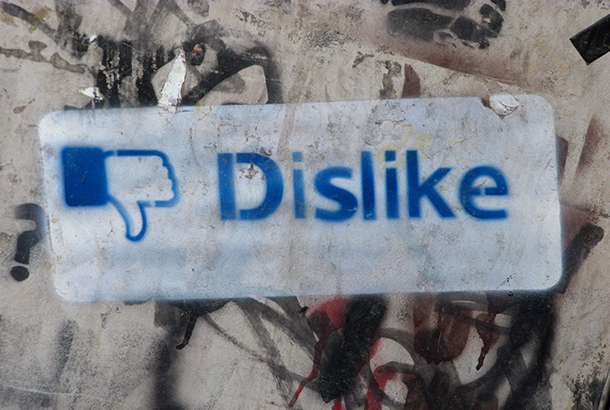 upside down facebook logo, next to the spray painted word dislike