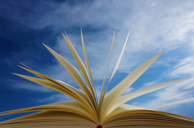 Photo of open book with blue sky in background