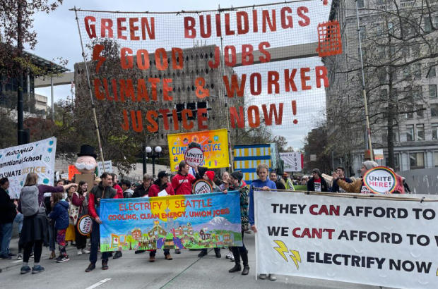 protest march in downtown seattle, protesters holding signs in support of seattle's green new deal