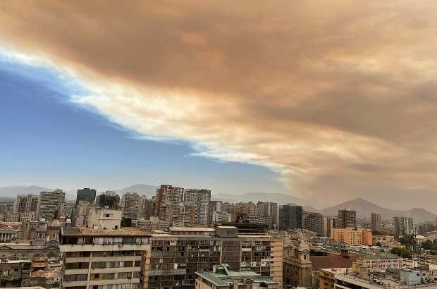 A photo looking over the city of Santiago, Chile, with dark hazy wildfire smoke coating the sky.