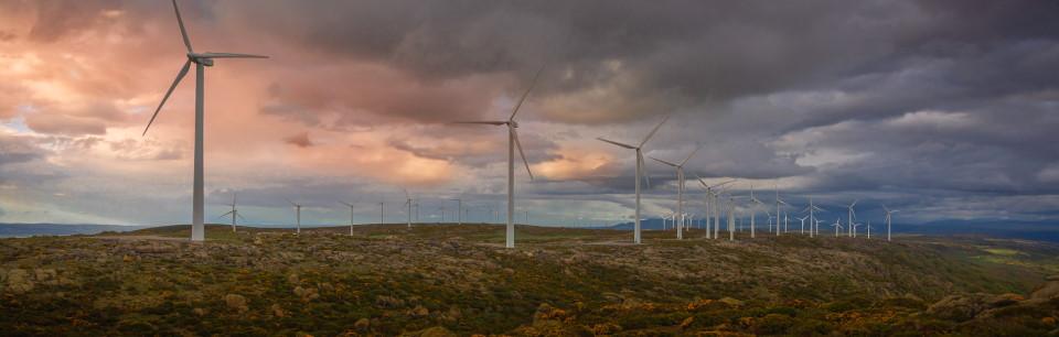 Photo of wind turbines over a colorful sky in Spain