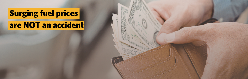 A picture of someone taking money out of their wallet in front of a car at a fuel pump.
