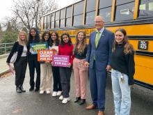 Gov. Jay Inslee with students in front of Electric school bus