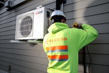 image of technician installing a heat pump