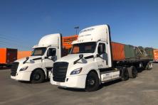 photo of two Freightliner electric drayage trucks