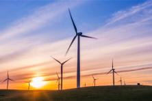 Photo of landscape at sunrise with wind turbines