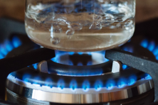 image of a gas burner boiling water in a clear glass pot
