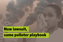 A picture of a child using her inhaler with smoke stacks in the background.
