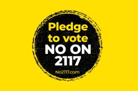 no on 2117 campaign logo, white text in black circle over gold background